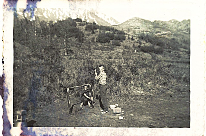 1959 - John and Linda - mother says on back of photo:  "This shows the small hill beyond (behind) our hut -- note scrubby bushes.  See the high mountain region still covered by snow way behind us.  Very beautiful in color.  John and Linda were making foundation for a tent."