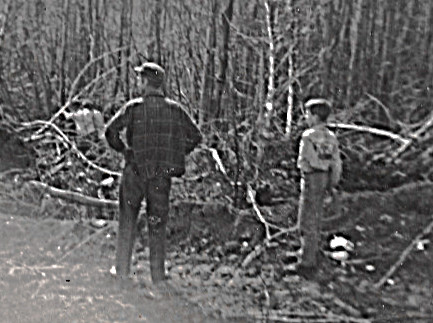 1960 ish dad closeup and john watching 2nd road going in -- actually they are watching the road being cordoroyed over the marshy areas -- So far this is my all time favorite picture of my oldest brother and my father
