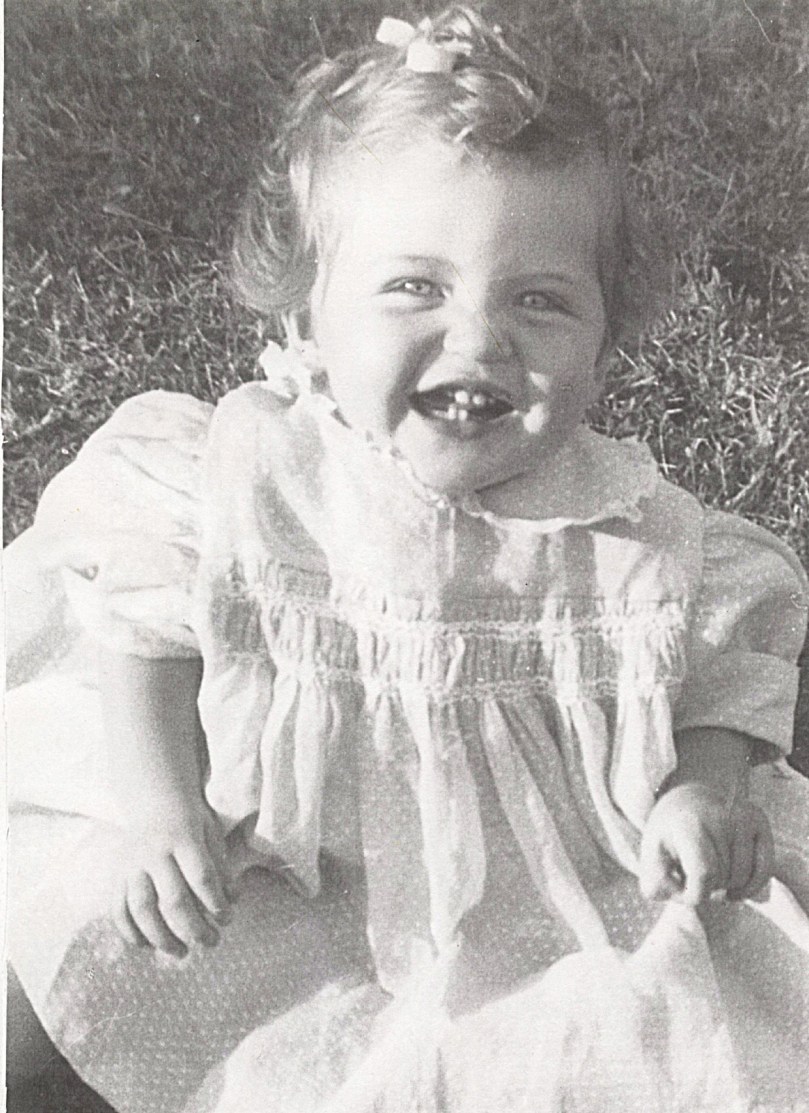 This is me at 11 months old, all dressed up with curls in my hair. This is me looking 'happy' during a picture taking event.
